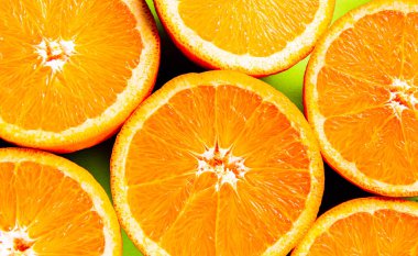 Kesikteki portakallar yeşil arkaplana karşı.