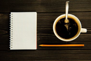 Kalem ve bir fincan kahve yeşil ahşap bir masada..