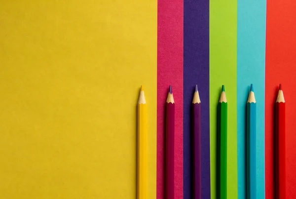 Цветные карандаши лежат на цветной бумаге . — стоковое фото
