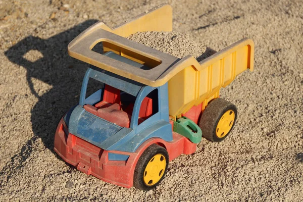Zabawka Plastikowa Niebiesko Czerwono Żółta Ciężarówka Żółto Czarnymi Kołami Piaskownicy — Zdjęcie stockowe