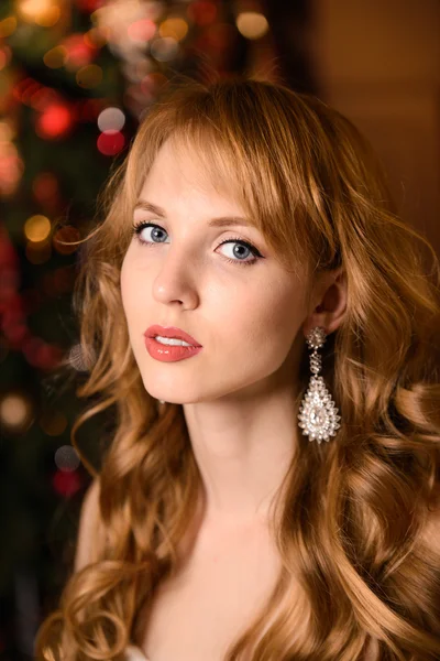 Young beautiful blond woman in the white dress on christmas, woman in a beautiful room with a Christmas tree and candles, a girl with gifts,  golden hair, happy woman new year, Redhead girl smiling — Stockfoto