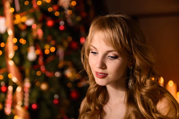 Young beautiful blond woman in the white dress on christmas, woman in a beautiful room with a Christmas tree and candles, a girl with gifts,  golden hair, happy woman new year, Redhead girl smiling — Stock fotografie