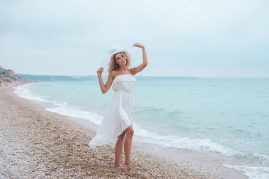 , bir mayo, kot şort, mutlu bir kadın, sahilde, neşeli kız seksi, ayaklarda su dalgalar üzerinde yürüme gülümseyen kadın sahilde, yürüyen güzel genç kadın