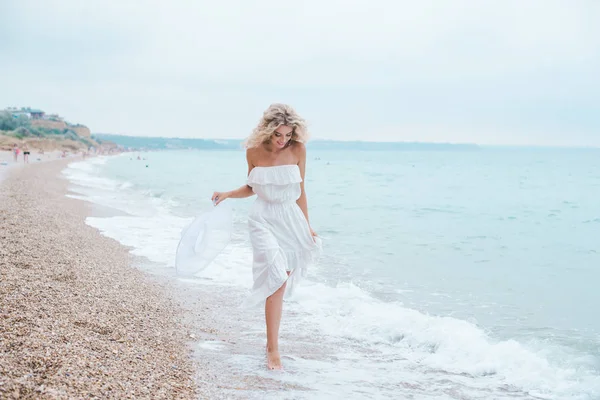 , bir mayo, kot şort, mutlu bir kadın, sahilde, neşeli kız seksi, ayaklarda su dalgalar üzerinde yürüme gülümseyen kadın sahilde, yürüyen güzel genç kadın