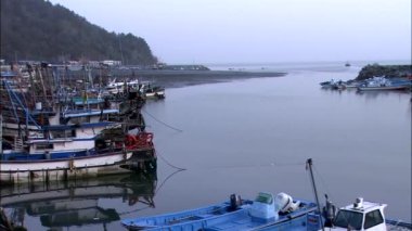 Arka plan üzerinde Dağları ile demirleyen deniz yüzeyi limanındaki balıkçı tekneleri