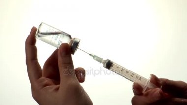 Doktor şırıngaya ilaç koyuyor.