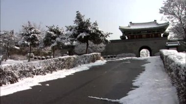 Temple gate ön plan üzerinde karlı çalılar ile geleneksel Kore mimarisi tarzında