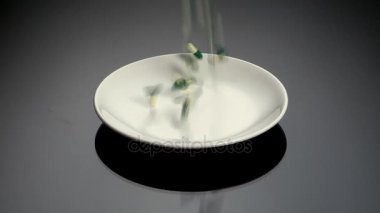 renkli hapları beyaz plaka üzerine düşen  