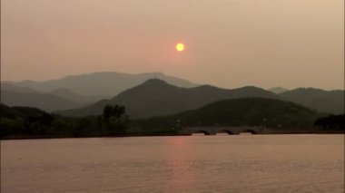 Deniz yüzeyinde yansıtan turuncu günbatımı