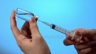 Doktor şırıngaya ilaç koyuyor.