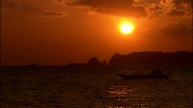 günbatımı sırasında denizde yüzen tekne 