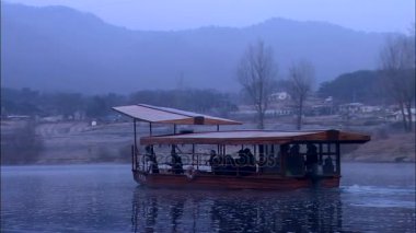 Nehirde yelken açan insanlarla dolu bir tekne.