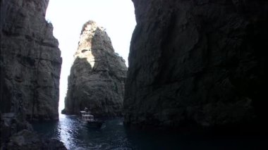 Kayalıklar arasında yüzen tekne ile deniz manzarası 