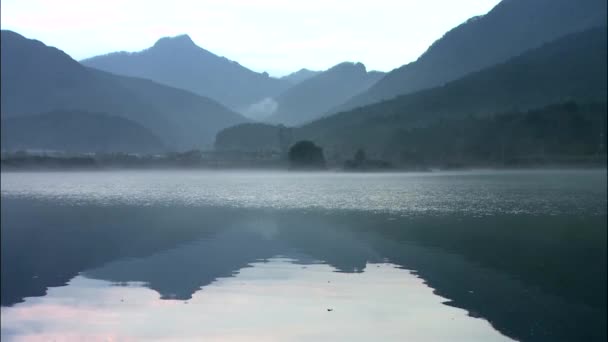 Hills reflecting on mirror surface of lake — Stock Video