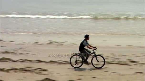 Jongen fietsten aan zandstrand — Stockvideo