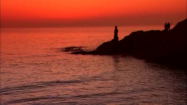 Sagome di persone sulla costa rocciosa — Video Stock