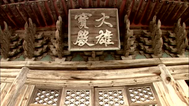 传统韩国建筑师风格的寺庙建筑中的木制标志 — 图库视频影像