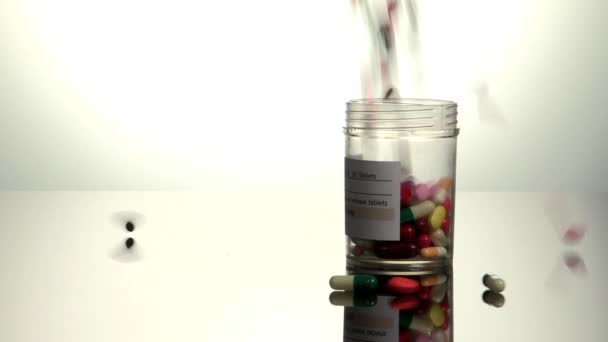 Таблетки, упавшие в бутылку с лекарством — стоковое видео