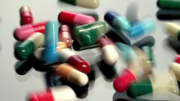 Pílulas que caem na mesa de vidro — Vídeo de Stock