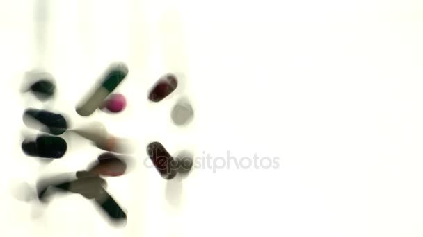 Pílulas que caem na mesa de vidro — Vídeo de Stock
