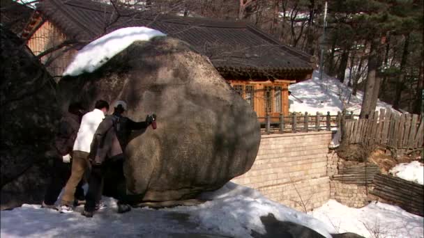 Ludzie próbują zrzucić kamień ze wzgórza — Wideo stockowe