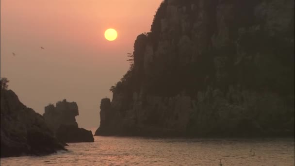 Barcos de pesca en el agua cerca de la isla rocosa — Vídeos de Stock