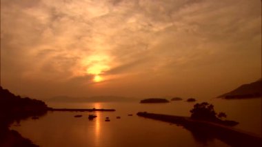 Deniz yüzeyinde yansıtan turuncu günbatımı