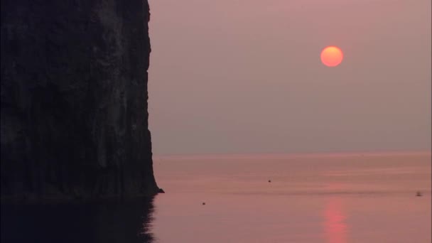 Puesta de sol sobre el mar y rocas — Vídeos de Stock