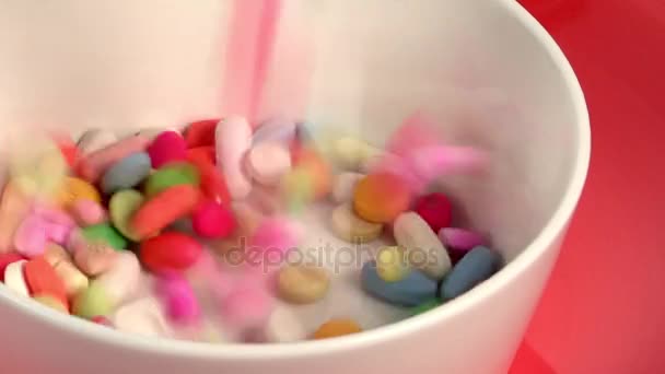 Colorful pills falling in white bowl — Stock Video