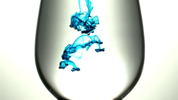 Aqua ink drops in wineglass — Stock Video