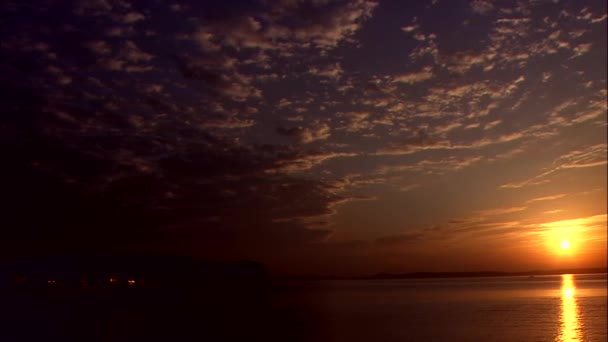 Pôr do sol laranja refletindo na superfície do mar — Vídeo de Stock