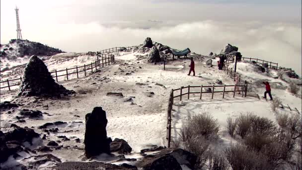 人们在雪山上漫步 背景上有云 — 图库视频影像
