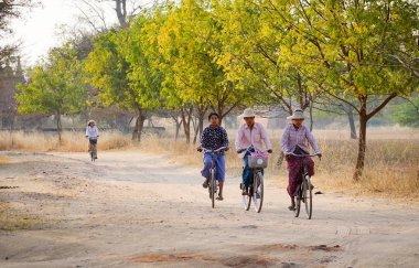 Bagan, Myanmar - 19 Şubat 2016. İnsanlar Bagan, Myanmar de kırsal yol bisikleti.