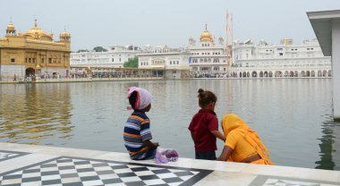 Amritsar, Hindistan - 25 Temmuz 2015. Amritsar, Hindistan Altın Tapınağı kutsal gölde su Sih insanlar almak.