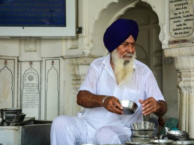 Amritsar, Hindistan - 25 Temmuz 2015. Amritsar, Hindistan Altın Tapınağı'nda süt veren bir Sih erkek.