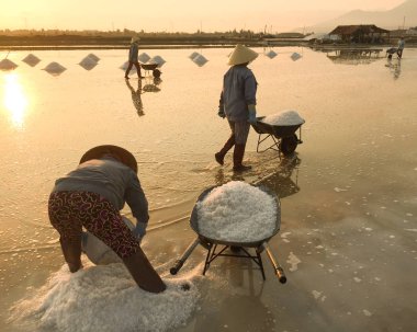 Konik şapka Ninh Hoa, Vietnam için tuz alanları üzerinde çalışan Vietnamlı kadınlarla. Yaklaşık 40 kilometre kuzeyinde Nha Trang, ortada büyük tuz alanı.