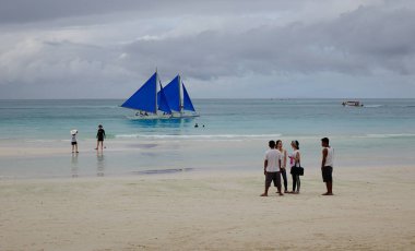 Boracay, Filipinler - 17 Aralık 2015. Teknelerden beyaz Beach Boracay, Filipinler turistlerle. Boracay bir tropik ada çarpıcı beyaz kumlu plajları tarafından çevrili olduğunu.