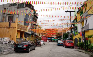 Manila, Filipinler - 20 Aralık 2015. Gecekondu bölgesi Manila, Filipinler, renkli bayrakları ile sokak görünümü. Manila Filipinler yaşam standardı çok güçlü kontrastlı başkentidir.