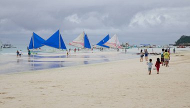 Boracay, Filipinler - 17 Aralık 2015. Teknelerden beyaz Beach Boracay, Filipinler insanlar. Boracay bir tropik ada çarpıcı beyaz kumlu plajları tarafından çevrili olduğunu.