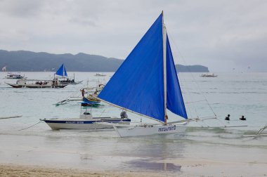 Boracay, Filipinler - 17 Aralık 2015. Mavi teknelerden beyaz Beach Boracay, Filipinler. Boracay onun güzel plajları ve büyük partiler için ünlüdür.