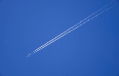 Uçak mavi gökyüzünün altında jettrail ile