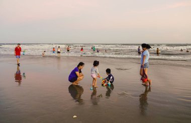 Vung Tau, Vietnam - 12 Kasım 2016. Vietnamca aileler Vung Tau, Vietnam için gün batımında sahilde oynarken. Vung Tau Saigon yakınındaki ünlü yerlerinden biridir.