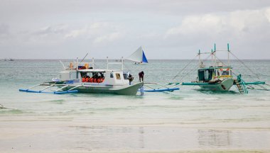 Boracay, Filipinler - 17 Aralık 2015. Turist tekneleri beyaz plaj Boracay, Filipinler bekliyor. Boracay bir tropik ada çarpıcı beyaz kumlu plajları tarafından çevrili olduğunu.
