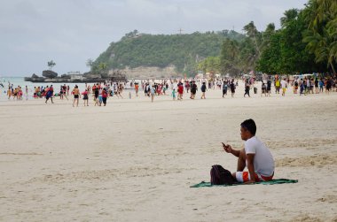 Boracay, Filipinler - 17 Aralık 2015. Oturma ve beyaz Beach Boracay, Filipinler zevk insanlar. Boracay bir tropik ada çarpıcı beyaz kumlu plajları tarafından çevrili olduğunu.