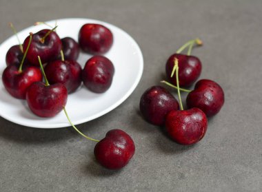 Taş yerdeki beyaz tabak taze kiraz kapandı.