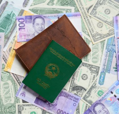M-cüzdan ve Vietnam pasaportu ile farklı ülkelerin birçok banknotlar masaya dağınık.