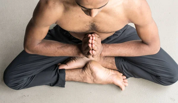 Yoga meditation man in the room and make a Zen symbol of him. Close-up of a male body.