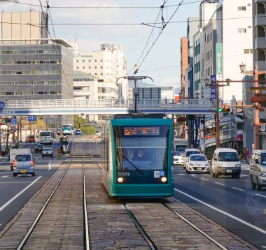 Hiroşima, Japonya - 28 Aralık 2015. Bir yeşil tramvay (tramvay) Hiroşima, Japonya rayına çalıştıran. Tramvay hizmeti 1912 yılında başlatıldı atom bombası tarafından kesildi.