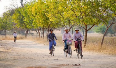 Bagan, Myanmar - 19 Şubat 2016. Birman kadınlar Bagan, Myanmar de kırsal yol bisikleti. Bagan olduğunu ev sahipliği Budist tapınaklar, pagodadan ve stupas en büyük ve en yoğun konsantrasyon.