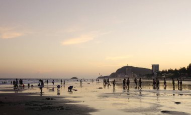 Vung Tau, Vietnam - 12 Kasım 2016. Vung Tau, Vietnam için gün batımında sahilde oynayan insanlar. Vung Tau Saigon yakınındaki ünlü yerlerinden biridir.